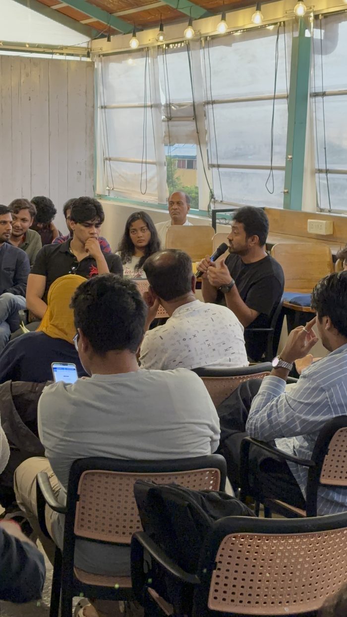 The audience at a past meetup, seated close together and turned towards a founder answering a question.